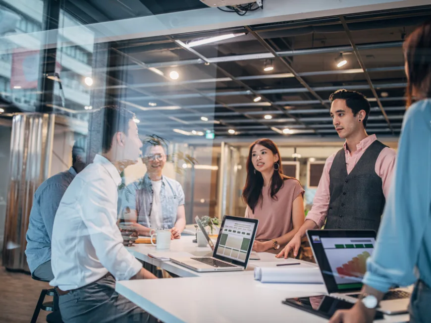 People standing around a desk in an office